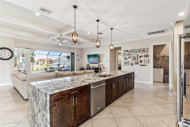 kitchen featuring decorative light fixtures, visible vents, open floor plan, a sink, and an island with sink