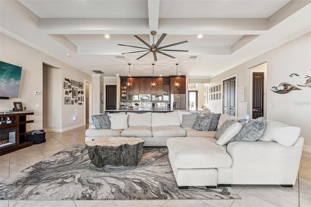 living area featuring a ceiling fan, visible vents, beamed ceiling, and baseboards