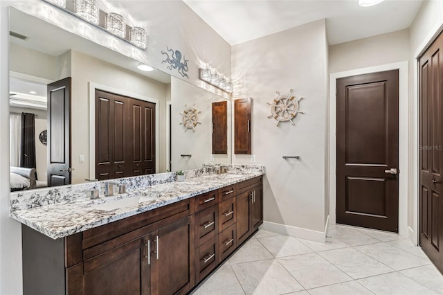 full bathroom featuring double vanity, baseboards, visible vents, and a sink