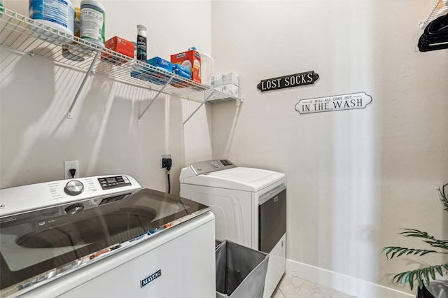 washroom with laundry area, washing machine and dryer, baseboards, and marble finish floor