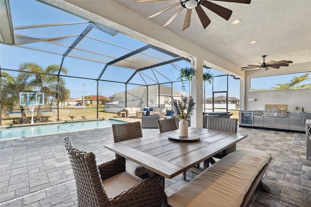 view of patio with area for grilling, ceiling fan, grilling area, a lanai, and outdoor lounge area