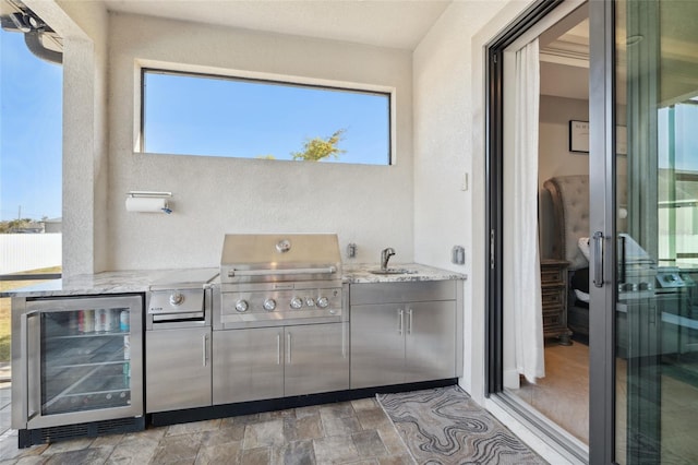 view of patio / terrace featuring beverage cooler, exterior kitchen, area for grilling, and a sink