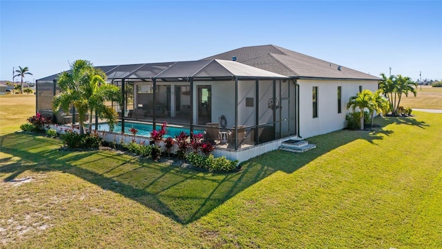 rear view of property featuring an outdoor pool, a lanai, a lawn, and stucco siding