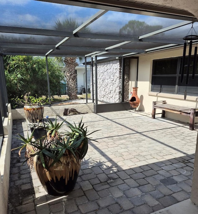 view of patio featuring glass enclosure