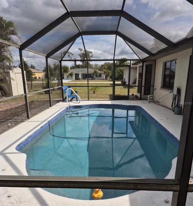 pool with a lanai, a lawn, and a patio