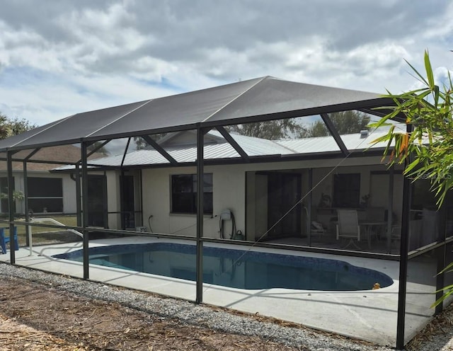 pool featuring a patio area and glass enclosure