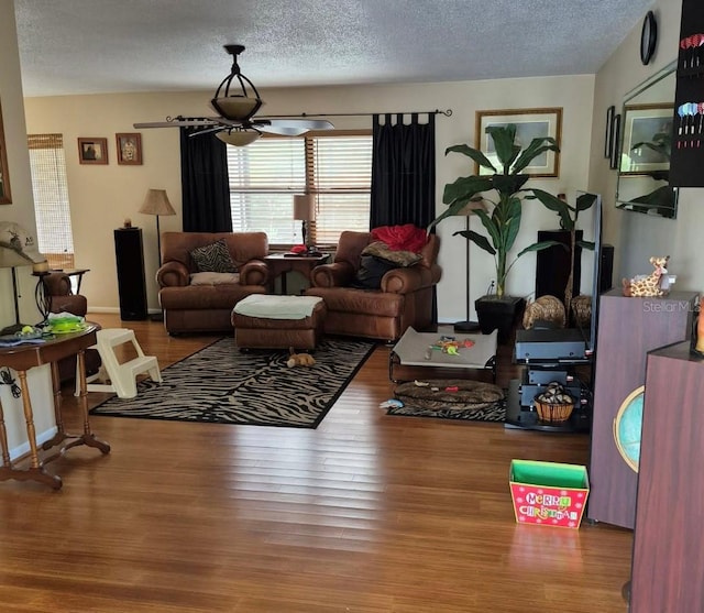 living area with a textured ceiling and wood finished floors