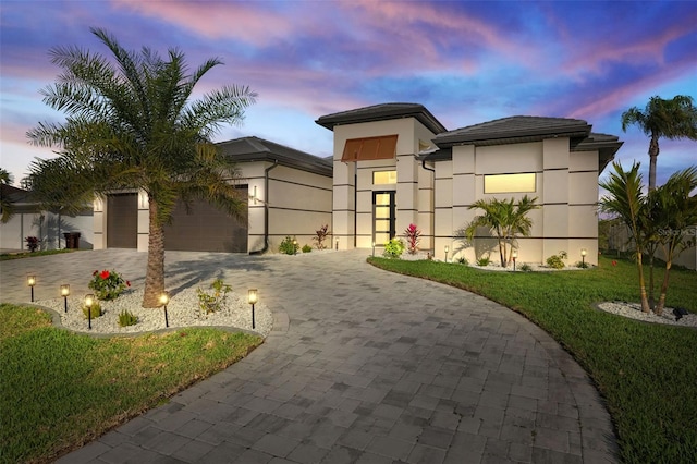 view of front of home with a garage and a yard