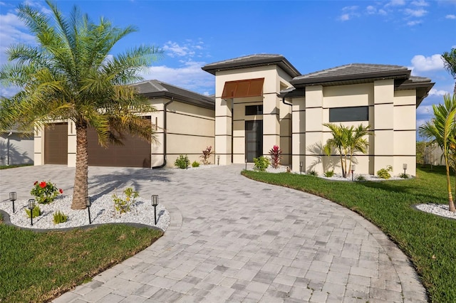 view of front of home with a front lawn and a garage