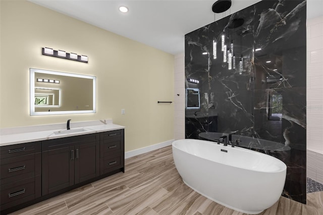 bathroom featuring wood-type flooring, tile walls, a bathtub, and vanity