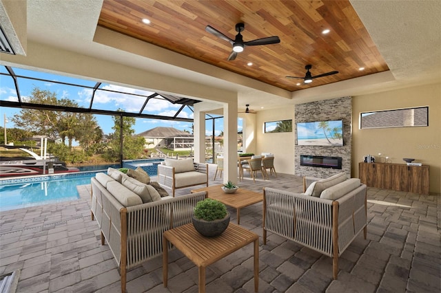 interior space featuring ceiling fan, an outdoor hangout area, and glass enclosure