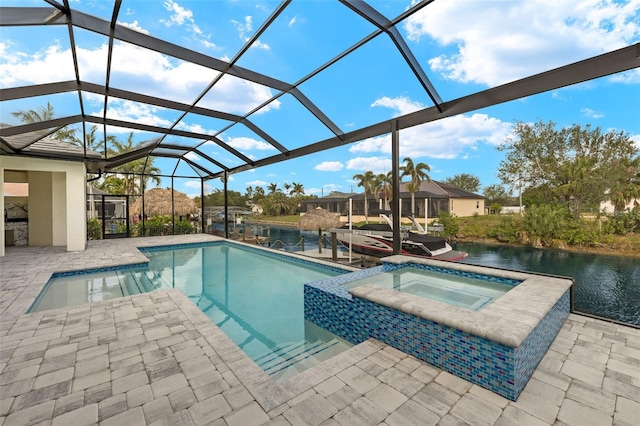 view of swimming pool featuring an in ground hot tub, glass enclosure, a patio area, and a water view