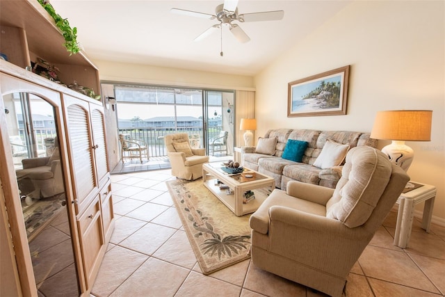 living area featuring vaulted ceiling, light tile patterned floors, and a ceiling fan