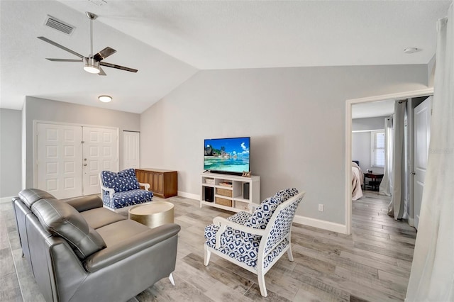 living room with light wood-type flooring, vaulted ceiling, and ceiling fan