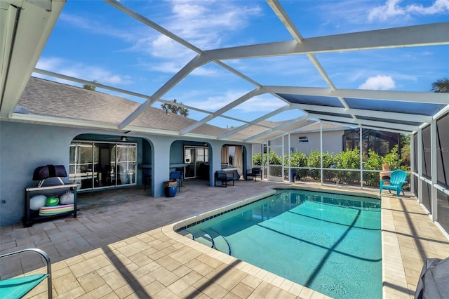 view of swimming pool featuring a patio and a lanai