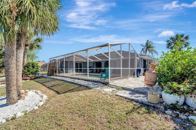 rear view of house with a lawn, a fenced in pool, a patio area, and glass enclosure