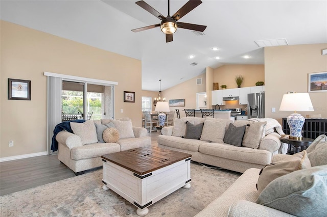 living room featuring high vaulted ceiling, light wood-style flooring, visible vents, and baseboards