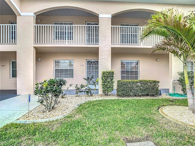 view of front of property featuring a front lawn and stucco siding