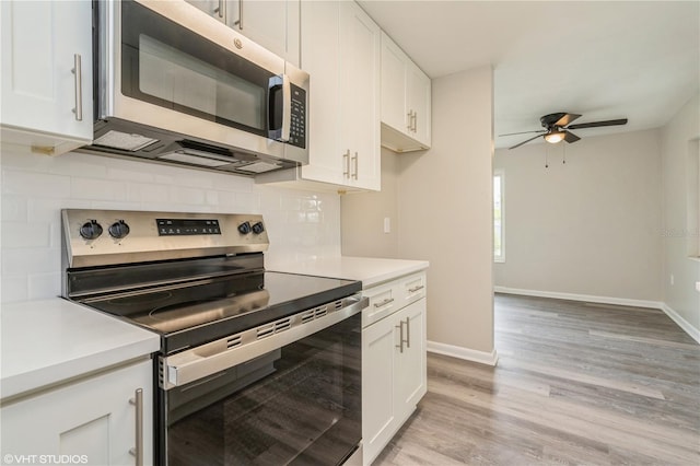 kitchen featuring light countertops, decorative backsplash, appliances with stainless steel finishes, light wood-style floors, and white cabinets