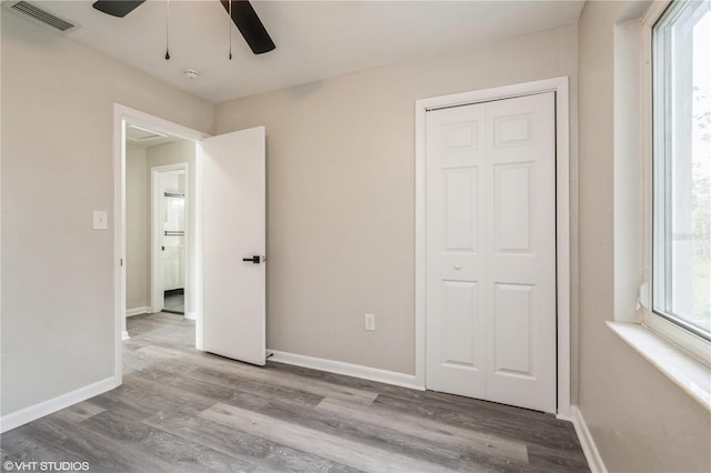 unfurnished bedroom with light wood-style flooring, a closet, visible vents, and baseboards