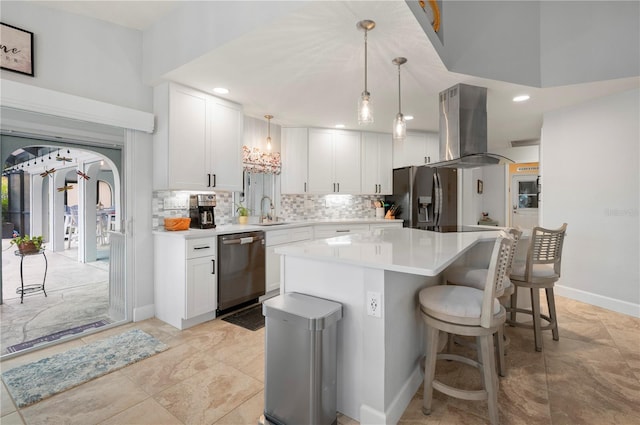 kitchen with arched walkways, island range hood, stainless steel appliances, white cabinets, and light countertops