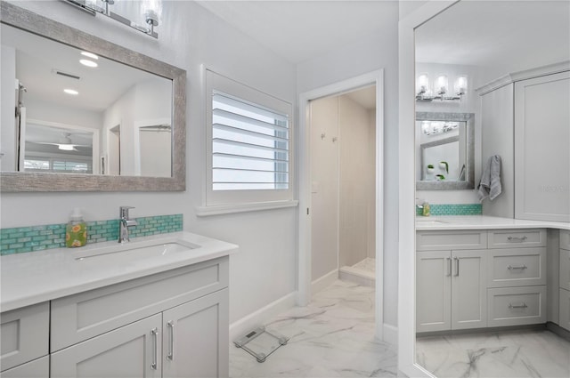 bathroom featuring two vanities, a sink, visible vents, baseboards, and marble finish floor