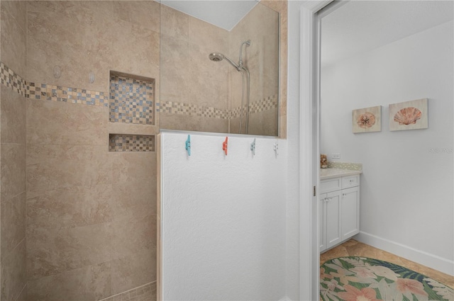 full bathroom featuring baseboards, walk in shower, and vanity