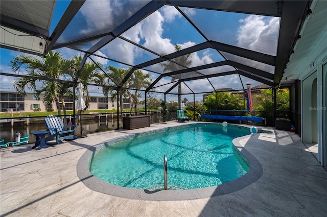 pool featuring a patio area, a water view, and a lanai