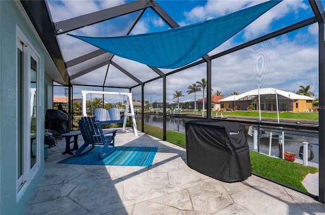 view of patio featuring glass enclosure, a water view, a boat dock, and area for grilling