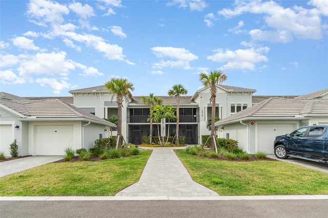 view of front of house featuring a garage, stucco siding, concrete driveway, and a front yard