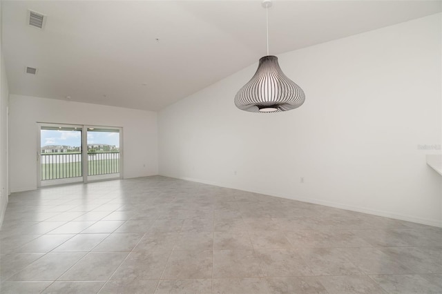 spare room featuring light tile patterned floors, lofted ceiling, visible vents, and baseboards