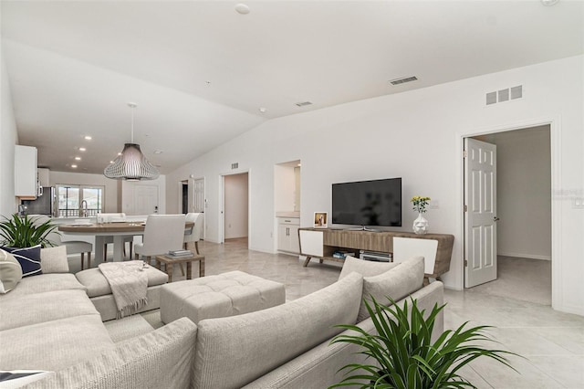 living room with lofted ceiling, visible vents, and baseboards