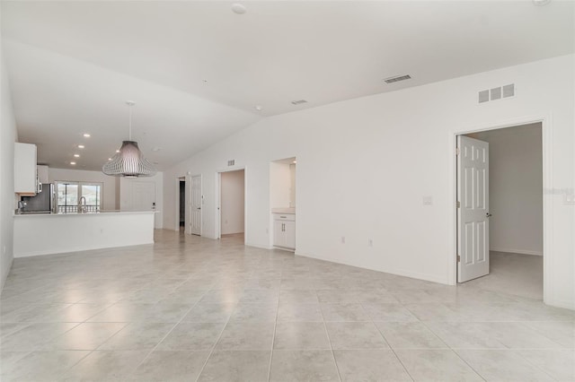 unfurnished living room featuring vaulted ceiling, light tile patterned floors, and visible vents