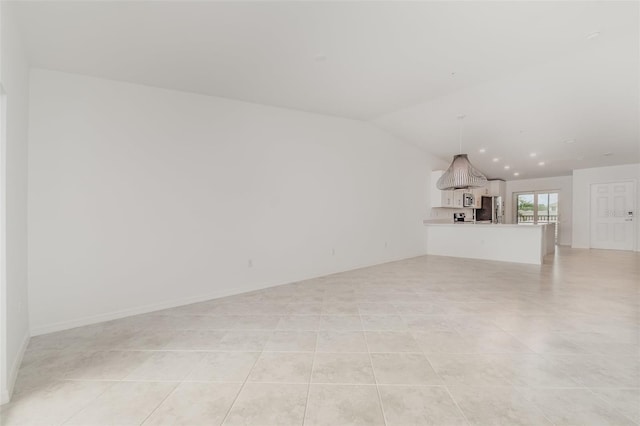 unfurnished living room with lofted ceiling and light tile patterned floors