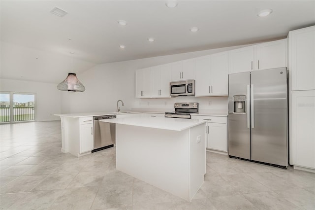 kitchen with light countertops, appliances with stainless steel finishes, white cabinetry, a kitchen island, and a sink