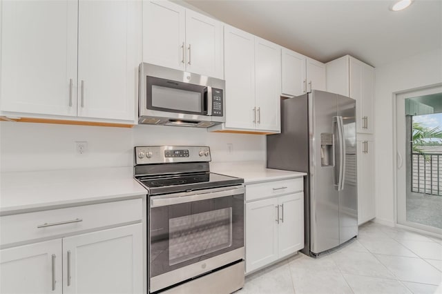 kitchen featuring stainless steel appliances, light countertops, and white cabinets