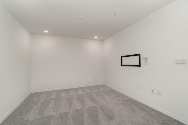 empty room featuring recessed lighting, light carpet, and baseboards