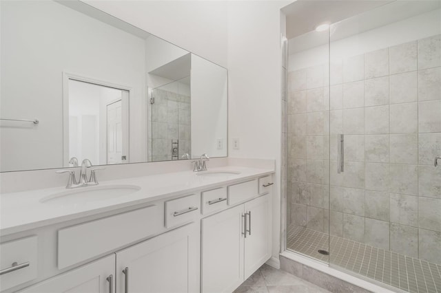 full bathroom with double vanity, tile patterned floors, a sink, and a shower stall