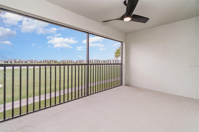 unfurnished sunroom with ceiling fan