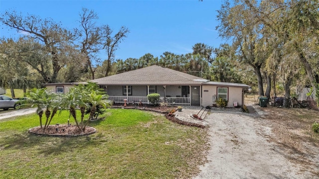 single story home featuring a front yard, covered porch, and driveway