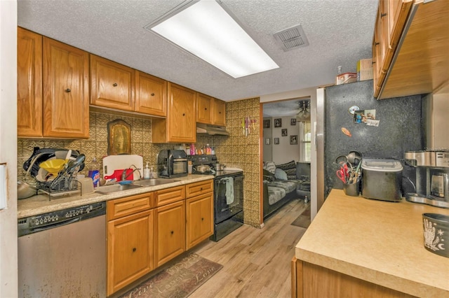 kitchen with light countertops, visible vents, stainless steel dishwasher, a sink, and black / electric stove