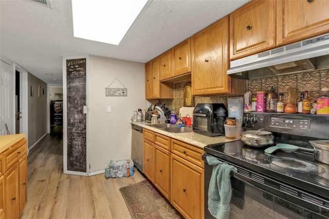 kitchen featuring electric range, light countertops, stainless steel dishwasher, under cabinet range hood, and a sink