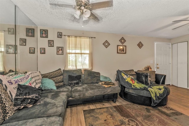 living area with a textured ceiling, wood finished floors, and a ceiling fan