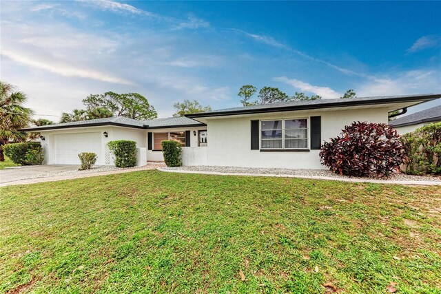 1052 Hinton St, Port Charlotte, FL 33952 - ranch-style home with stucco siding, an attached garage, concrete driveway, and a front lawn