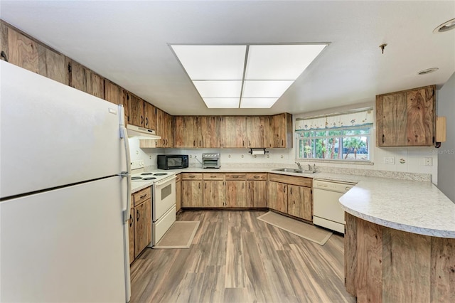 1052 Hinton St, Port Charlotte, FL 33952 - kitchen featuring light wood finished floors, under cabinet range hood, light countertops, white appliances, and a sink