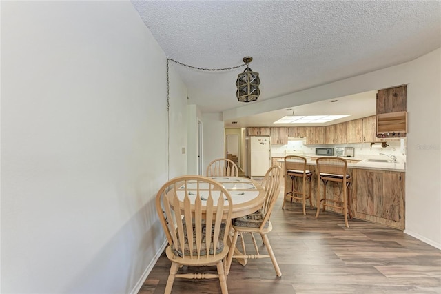 1052 Hinton St, Port Charlotte, FL 33952 - dining space with wood finished floors, baseboards, and a textured ceiling