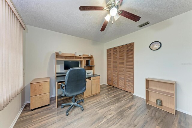 1052 Hinton St, Port Charlotte, FL 33952 - office featuring visible vents, baseboards, ceiling fan, light wood-type flooring, and a textured ceiling