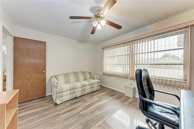 1052 Hinton St, Port Charlotte, FL 33952 - home office with baseboards, a textured ceiling, a ceiling fan, and wood finished floors
