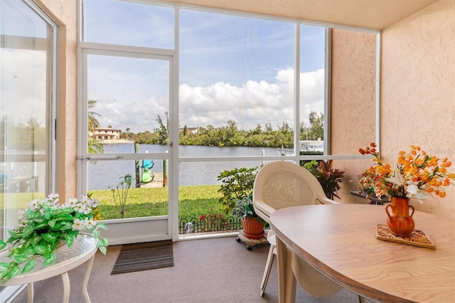 sunroom / solarium featuring a water view