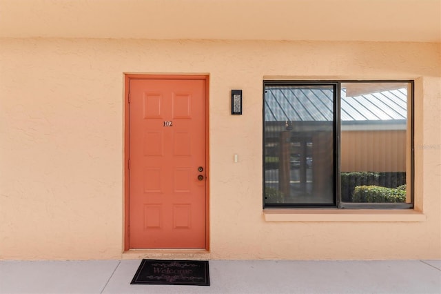 view of exterior entry featuring stucco siding